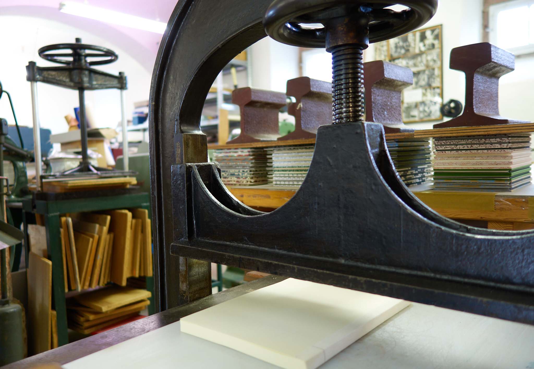 Blick in die Kartonagenwerkstatt: alte Buchbinderpressen. Im Hintergrund: Fertige Leporellos während der Trocknung.