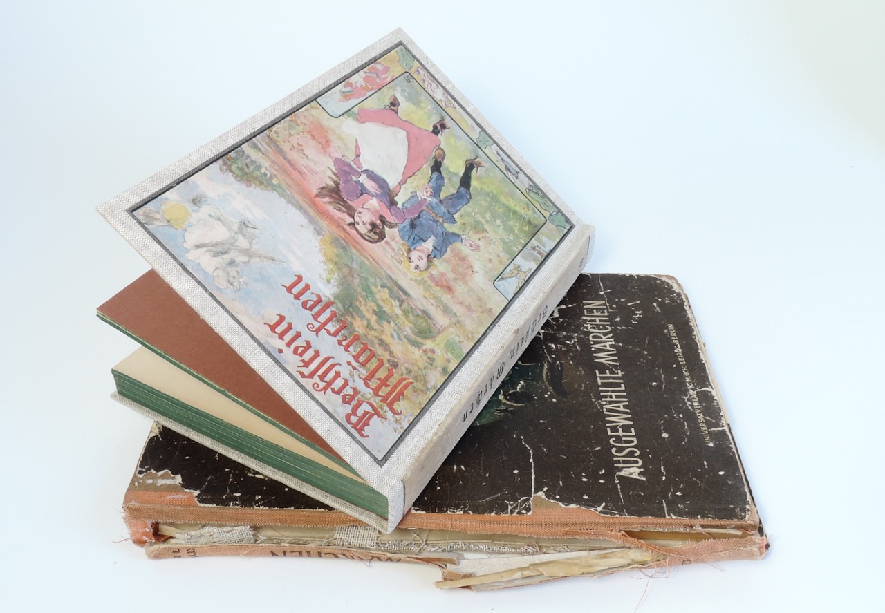 Zwei alte Märchenbücher, davon je eines vor und nach der Reparatur.