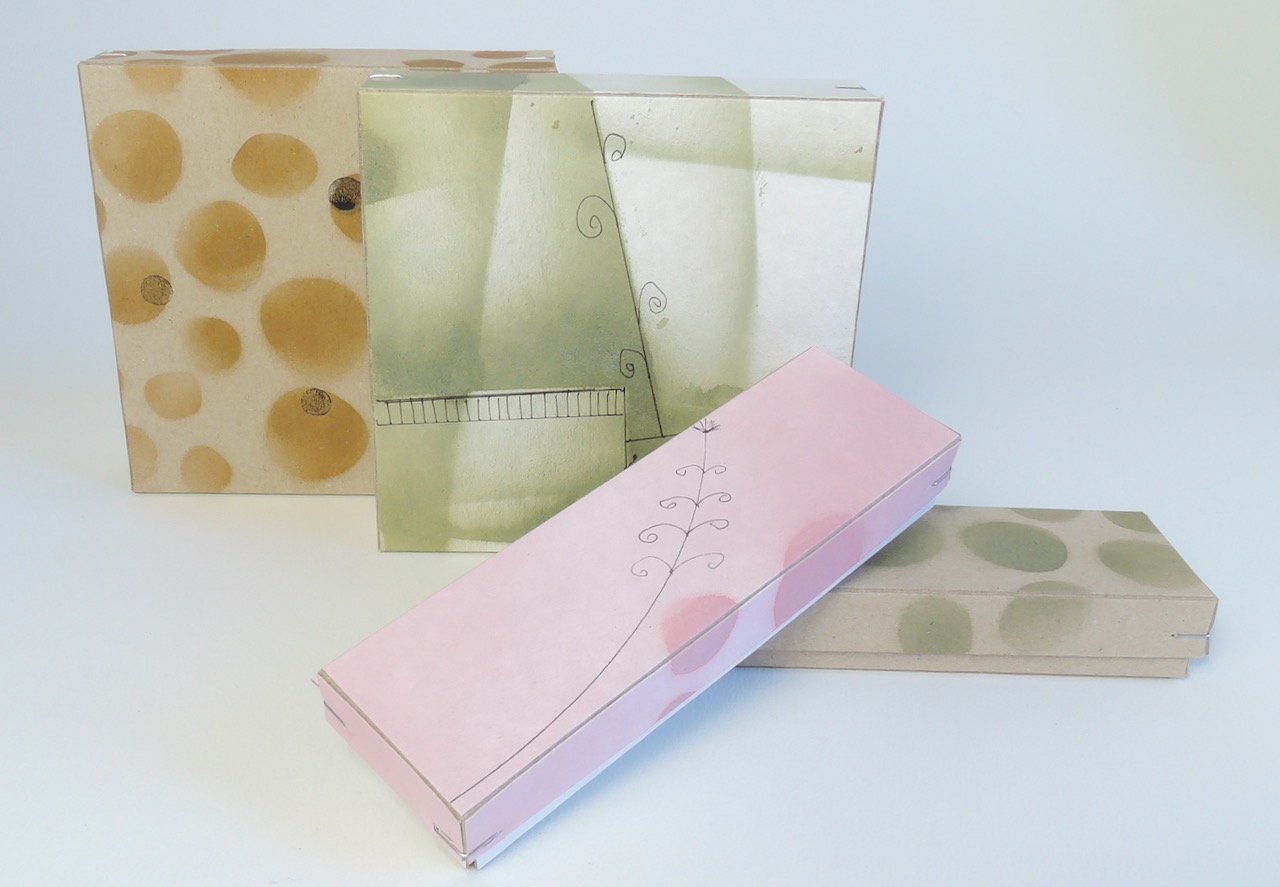 Vier kleinen Schachteln aus Graupappe mit farbigen Spritzdekor