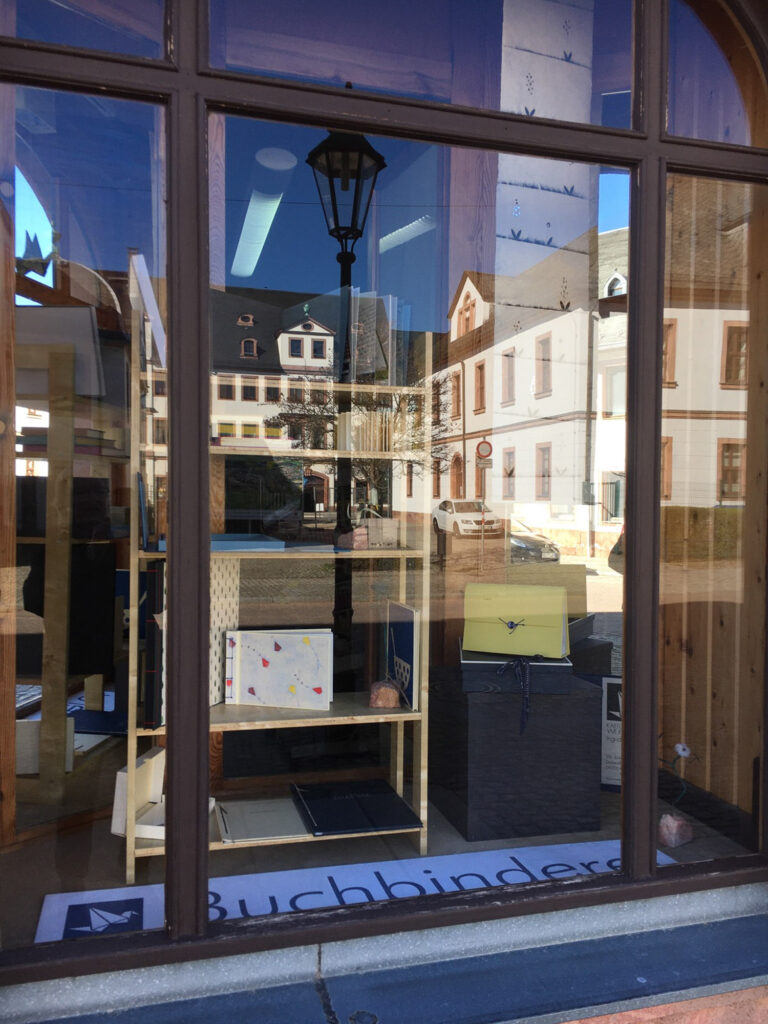 Schaufenster des Strickliesels" in Rochlitz mit Fotoalben, Schachteln und anderen Artikeln aus der Kartonagenwerkstatt I. Trommer, Königshain.